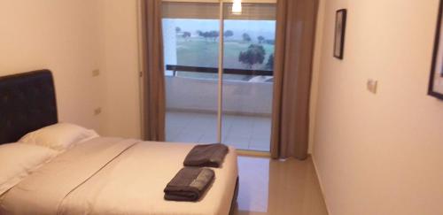 - une chambre avec un lit et une grande fenêtre dans l'établissement Marina golf assilah مارينا كولف أصيلة, à Assilah