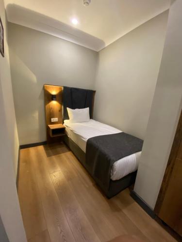 a small bedroom with a bed and a wooden floor at Zeyn Otel Istanbul in Istanbul