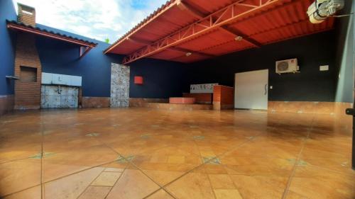 um quarto amplo com piso em madeira e paredes azuis em MOTEL HORA EXTRA em Jataí