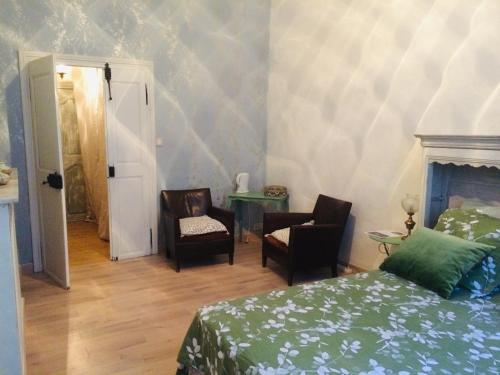 a bedroom with a bed and two chairs and a table at SAUVEURS DE REVES 2 suites indépendantes et un F2 privé dans un hôtel particulier in Sauve