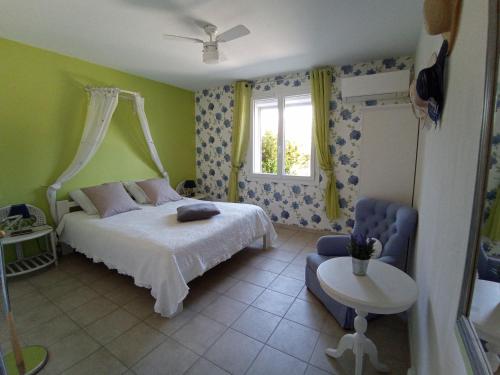 um quarto com uma cama, uma cadeira e uma janela em AU VILLADIOR - Vaison la Romaine em Vaison-la-Romaine
