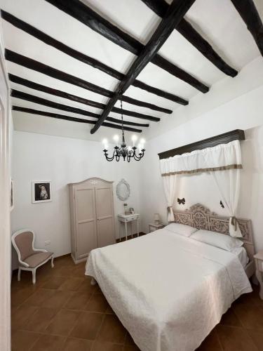 1 dormitorio con cama blanca y lámpara de araña en Dimora Chloé en Marsala