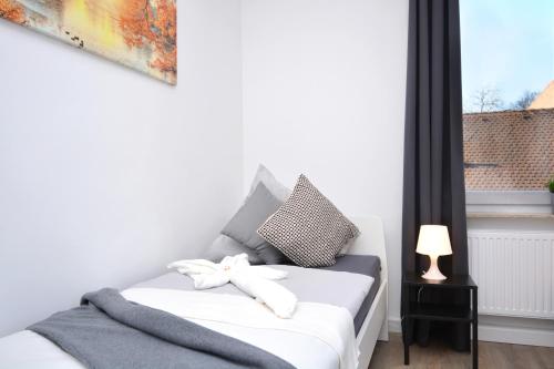 una piccola camera con un letto bianco e una finestra di NUE08-RI Apartment in Zirndorf a Zirndorf