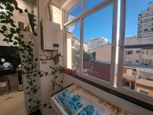 Una ventana en una habitación con una almohada y una planta en Quarto privativo no melhor de Botafogo com Anfitriã - home with host en Río de Janeiro