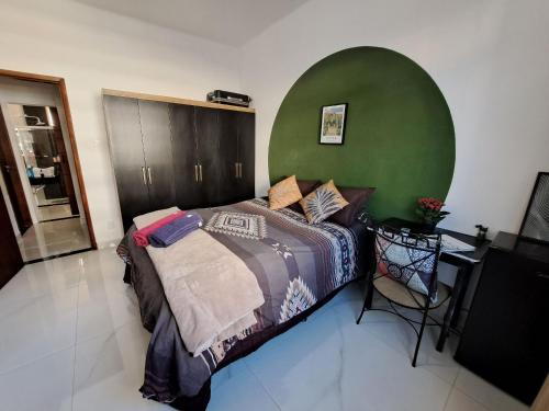 1 dormitorio con cama y pared verde en Quarto privativo no melhor de Botafogo com Anfitriã - home with host en Río de Janeiro