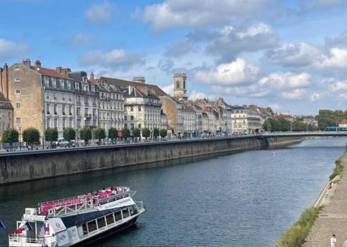 um barco a descer um rio numa cidade em La perla em Besançon