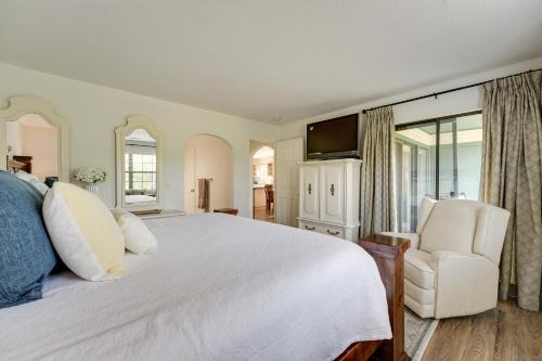 een slaapkamer met een groot wit bed en een stoel bij Branson Condo Near 76 Strip and Silver Dollar City in Branson