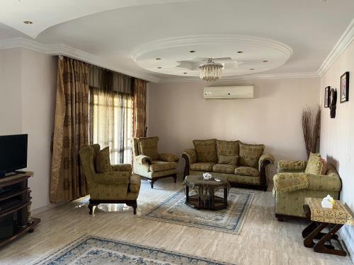 Rehab City VIP Full Serviced Apartment الرحاب Guest satisfaction guaranteed في القاهرة: غرفة معيشة مع أريكة وكراسي وتلفزيون
