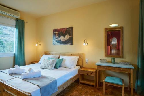 a bedroom with a bed and a table and a mirror at Primavera Suite in Stalida