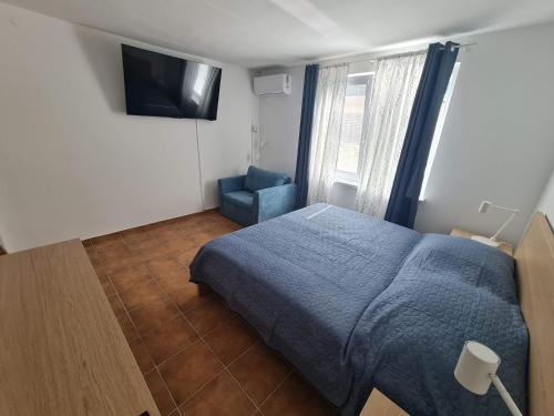 a bedroom with a blue bed and a blue chair at Apartmány Modrý deň in Bojnice