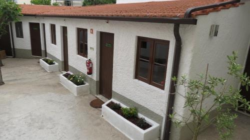 a house with three flower pots on the side of it at Alojamento Local Duarte's in Coimbra