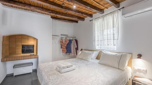 1 dormitorio con cama blanca y ventana en Milos Bay View, en Zefiría