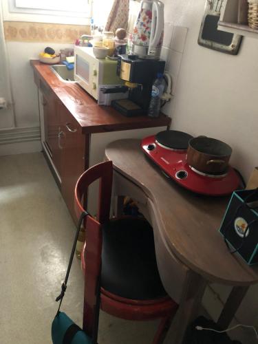 - une cuisine avec un bureau en bois et un four micro-ondes dans l'établissement Charming Relais Poste 17ème, à Paris