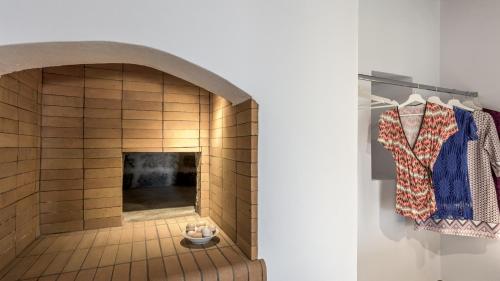 a room with a fireplace and a shirt on a rack at Milos Bay View in Zefiría