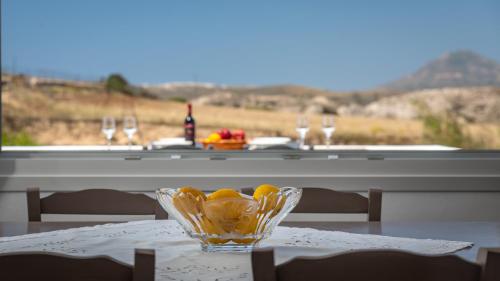a table with a glass bowl of lemons on it at Milos Bay View in Zefiría