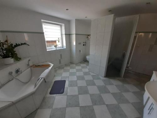 ein Bad mit einer Badewanne, einer Dusche und einem Waschbecken in der Unterkunft Ferienwohnung Kreiller in Johanniskirchen