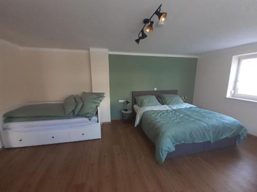 ein Schlafzimmer mit einem Bett, einem Sofa und einem Fenster in der Unterkunft Ferienwohnung Kreiller in Johanniskirchen