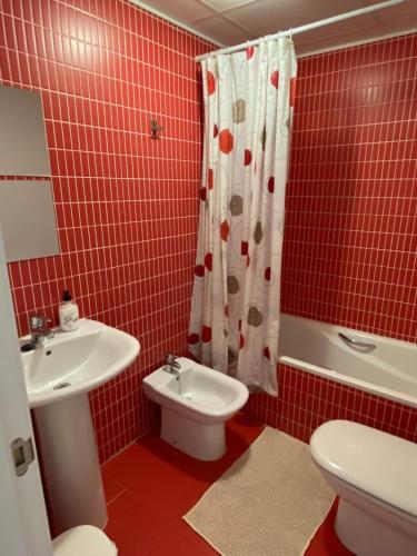 La salle de bains est pourvue de carrelage rouge, de toilettes et d'un lavabo. dans l'établissement Apartamento VI-DA SOL, à Puerto de Sagunto