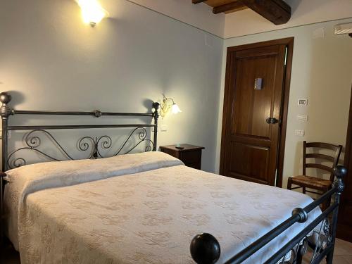 a bedroom with a large bed and a wooden door at Agriturismo Le Sorgenti in Norcia