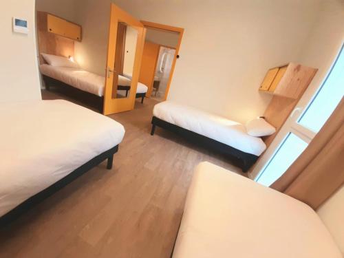 a small room with two beds and a mirror at greet hotel Castets Coeur des Landes in Castets