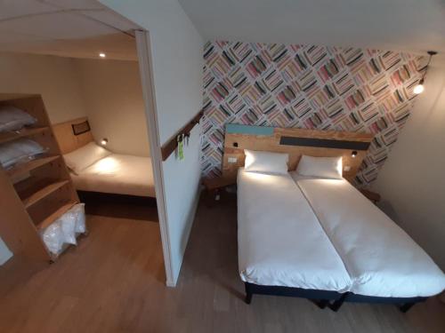 a small room with a bed and a mirror at greet hotel Castets Coeur des Landes in Castets