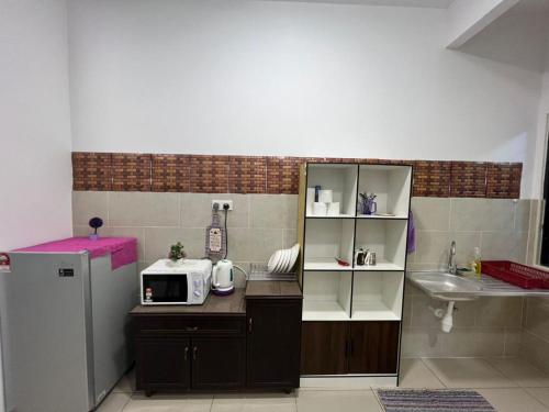 a small kitchen with a microwave and a sink at Barget and Lovely House at Atlantis in Melaka