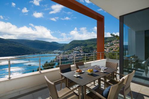 a table and chairs on a balcony with a view at Park Hill Residences in Rabac
