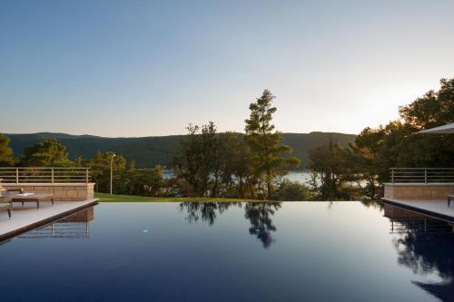 a swimming pool with a view of a lake at Park Hill Residences in Rabac