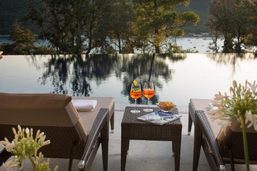 a table and chairs next to a body of water at Park Hill Residences in Rabac