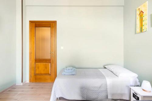 1 dormitorio con 1 cama y puerta de madera en Appartamento Dante en Novi Ligure