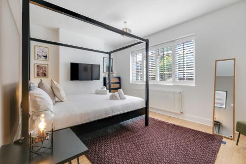 a bedroom with a large bed and a mirror at Luxury 3 Bedroom 2 bathroom House, Fulham SW6 By 360Stays in London