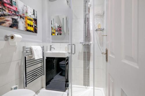 a bathroom with a shower and a toilet and a sink at Luxury 3 Bedroom 2 bathroom House, Fulham SW6 By 360Stays in London