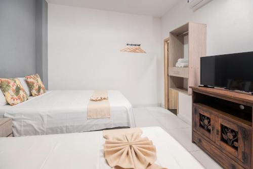 a white room with a bed and a tv at Hotel París in Villeta