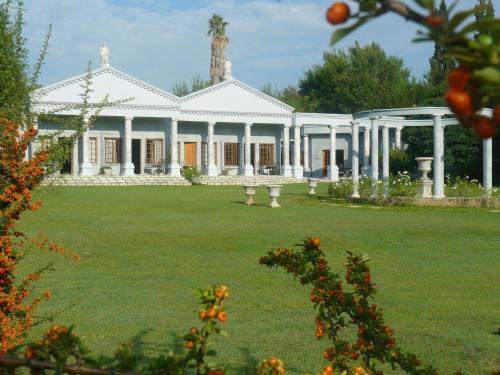 a large white house with a large yard at Ancient Emperor Guest Estate in Potchefstroom