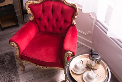 a red chair with a table in a room at Chic Appart - Sauna privatif in Tourcoing
