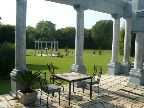 a patio with a table and chairs and a garden at Ancient Emperor Guest Estate in Potchefstroom