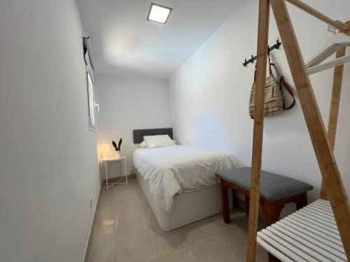 een witte slaapkamer met een bed en een stoel bij Sonneland , Sonemar in Sonnenland