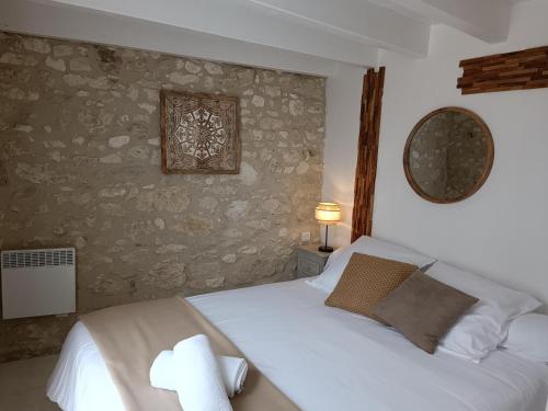 1 dormitorio con cama blanca y pared de piedra en Gite Chambre Naomie, en Parranquet