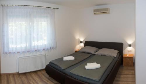 sypialnia z łóżkiem z dwoma białymi ręcznikami w obiekcie Oázis apartman w mieście Keszthely
