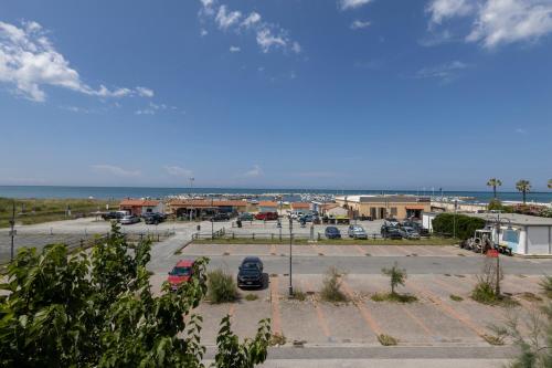 a parking lot with cars parked in it next to the ocean at Hotel Quisisana in Vada