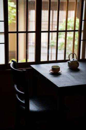 a table with two cups and a tea pot on it at Kyo no Yado Sangen Ninenzaka in Kyoto
