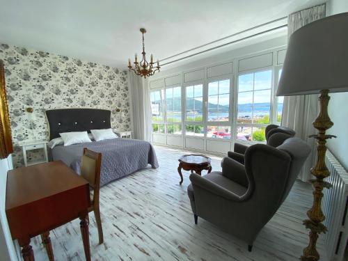 - une chambre avec un lit, une chaise et un canapé dans l'établissement Pensión Residencia J. Lago, à Muros