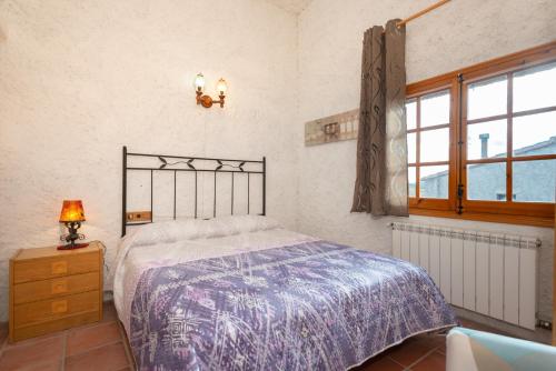 1 dormitorio con cama, lámpara y ventana en Casa perfecta para una experiencia en el Priorat, en Gratallops