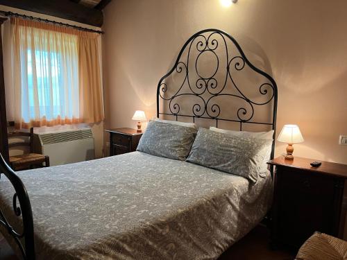 a bedroom with a large bed with a large headboard at Agriturismo Le Sorgenti in Norcia