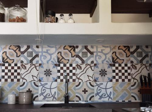 cocina con azulejos azules y blancos en la pared en La casa sulla Terrazza, en Sarnico