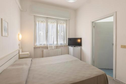 a bedroom with a large bed and a television at Hotel Quisisana in Vada