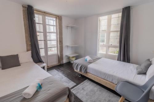1 Schlafzimmer mit 2 Betten, einem Sofa und Fenstern in der Unterkunft Hostal San Pelayo in Santiago de Compostela