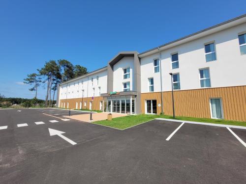 an empty parking lot in front of a building at greet hotel Castets Coeur des Landes in Castets