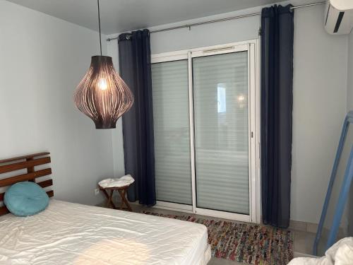 ein Schlafzimmer mit einem Bett und einem großen Fenster in der Unterkunft Villa coucher de soleil sur mer in Algajola