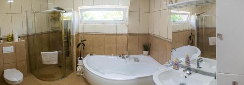 W łazience znajduje się wanna, umywalka i prysznic. w obiekcie Oázis apartman w mieście Keszthely